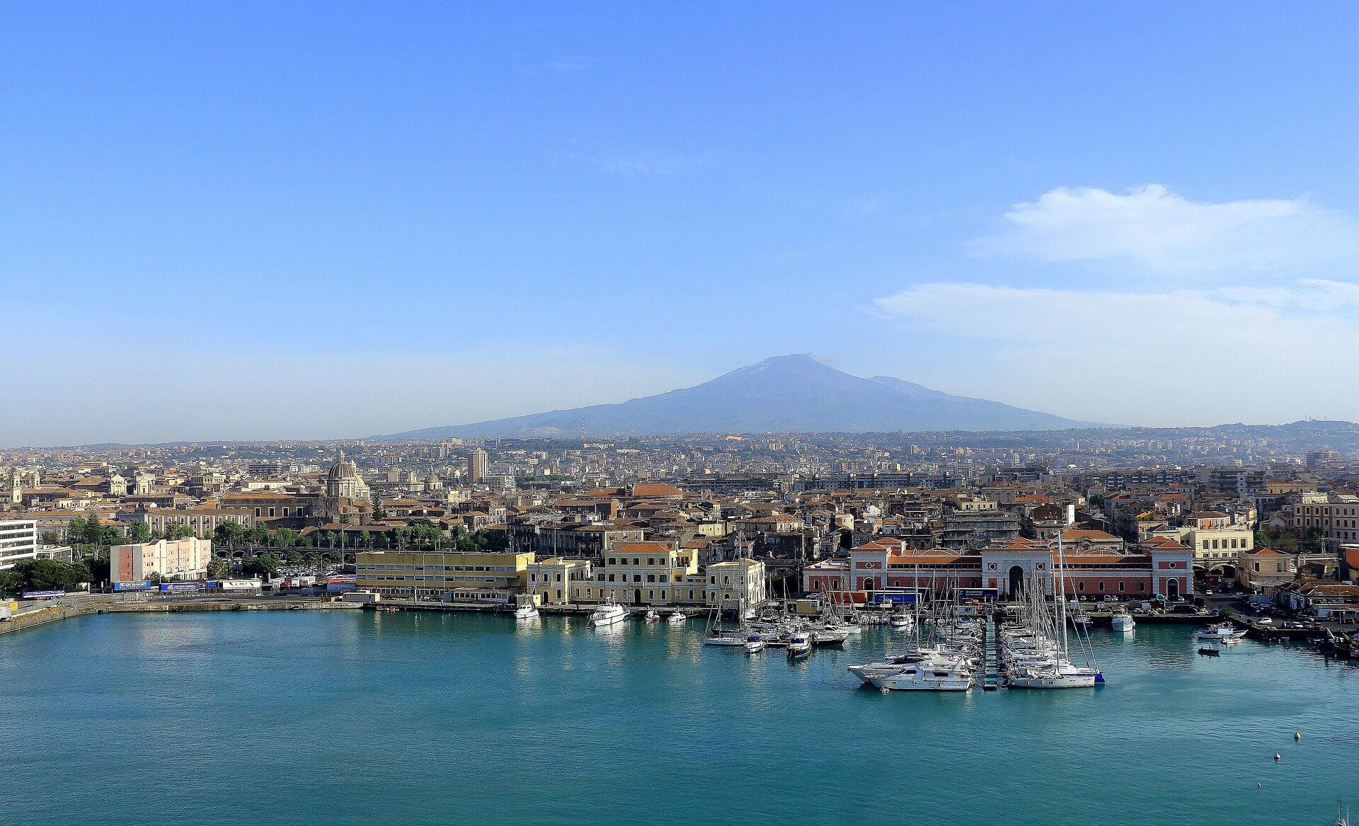 Catania vom Wasser aus mit Sicht auf das Hafengebäude (rot)